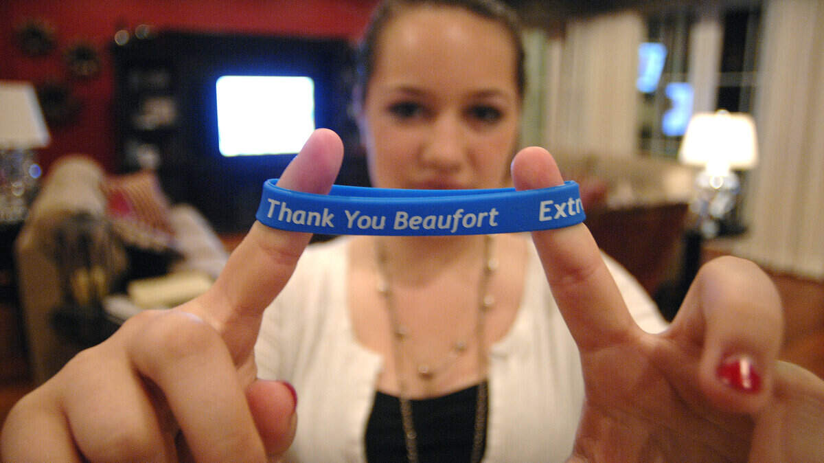Briana Stone, 11, holds up a "Thank You" bracelet her mother had created for all the people who helped them.