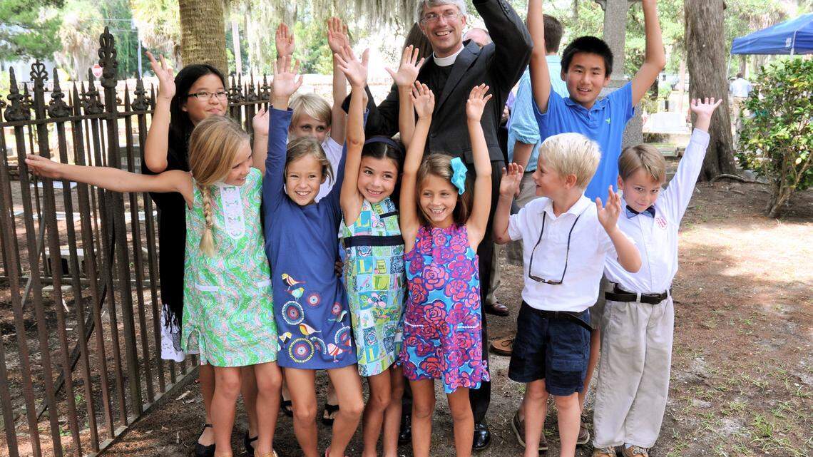 The Rev. Chad Lawrence and students at Holy Trinity Classical Christian School in Beaufort celebrate the announcement of a large donation to support scholarships on Sept. 7, 2014. The school raised more than $750,000 to meet a matching donor challenge, resulting in the $1.7 million Farrell and Elizabeth Runyan Scholarship Fund.