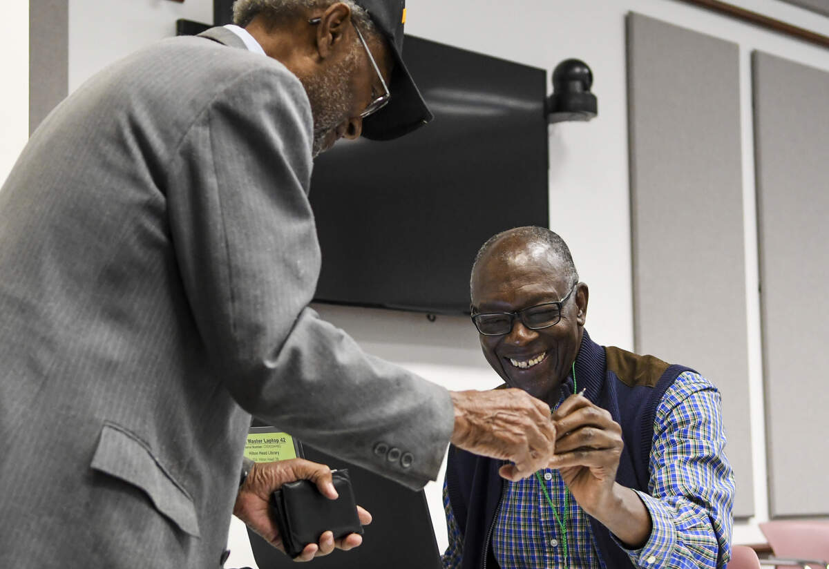 Poll clerk and Hilton Head Island resident David White, center, returns a voter’s drivers license at the Hilton Head Island Library where two island districts – 2B and 3 – were asked to vote yes or no for the Beaufort County School District’s $345 million bond referendum.