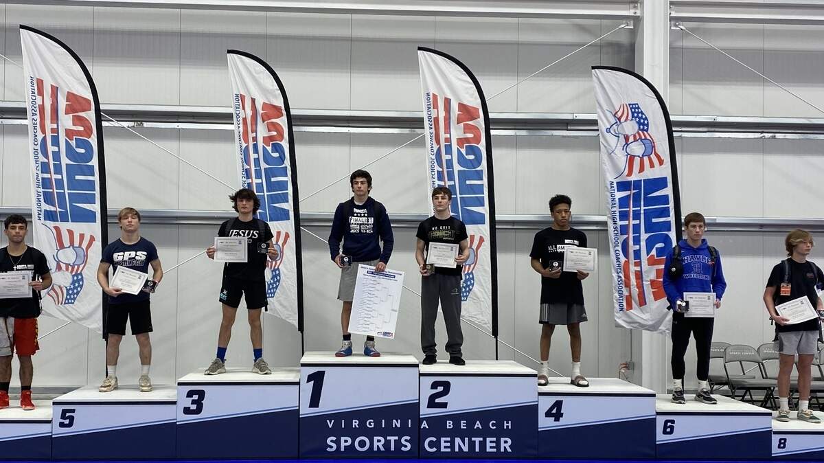 Levy (left) stands on the third-place podium with other wrestlers at the Virginia Beach Sports Center to accept his All-American title.