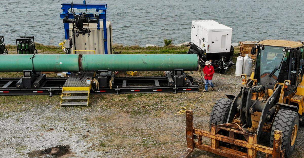 A worker walks around to the front of an automatic welder on April 5, 2022 at the Port of Port Royal. Christopher Clark Sr., with Harbor Masters International, said the machine welds two pilings together. Pipes are being staged at Port of Port Royal and transported to Charleston as part of a marina expansion project at that location.