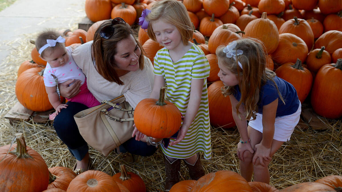 Christine Jezewski, left, of Beaufort, holds her youngest daugther Elena Jo, 7-months-old, while looking for the a pumpkin with her niece, Audrianna Smith, 4, center, and her oldest daugther Emily, 6, on Oct. 12, 2015, at Carteret Street United Methodist Church in Beaufort.