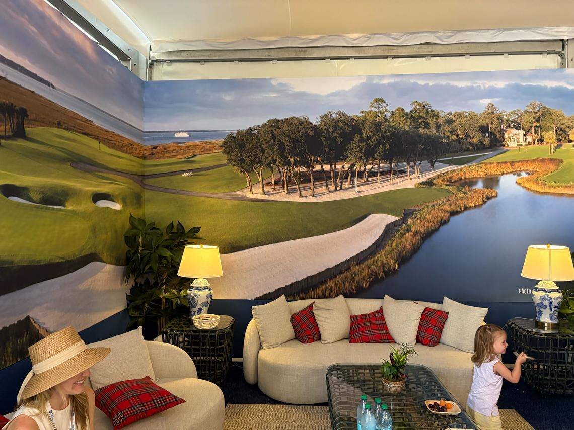 White couches are inside the Calibogue Club at RBC Heritage, underneath photos of Harbour Town Golf Links