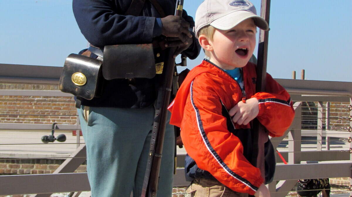 Matt Richardson's son Jake is all smiles as he participates in a make-believe musket drill while Ray Christie, a historical interpreter depicting a Civil War soldier of the Federal Army's 55th Massachusetts, looks on.