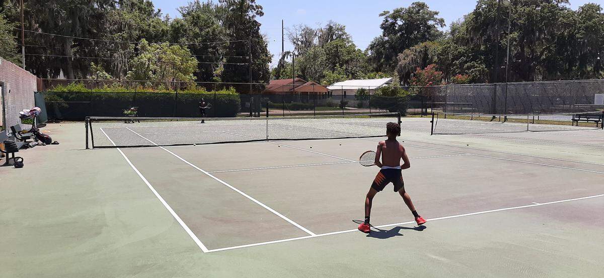 Jeremy Alston, foreground, plays tennis Friday with Sedeek Prather at the tennis courts at 1105 Bladen St. in Beaufort. The seven courts will be resurfaced this fall.