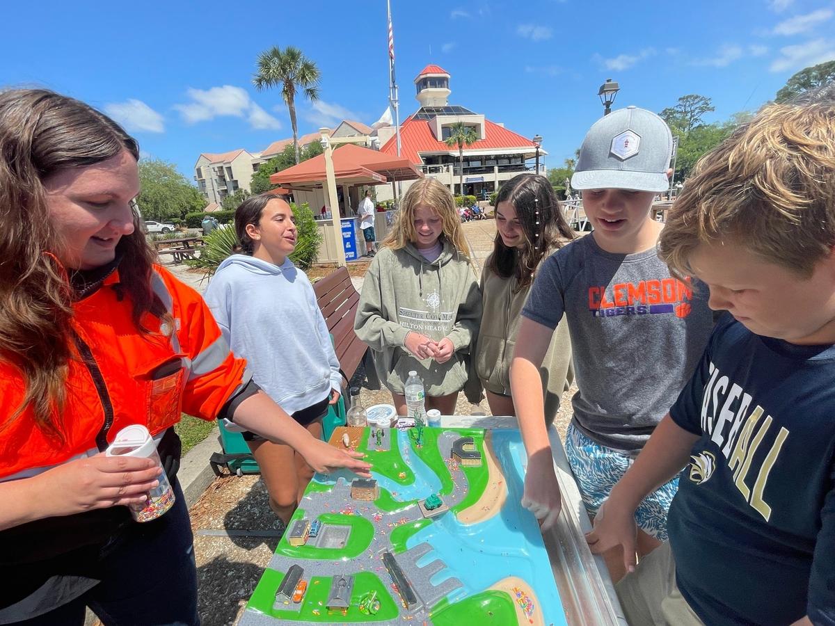 Hilton Head Christian Academy students work with volunteer Ellen Sturup Comeau to learn about water pollution using sprinkles and a model town Monday, May 9, 2022 on Hilton Head Island.
