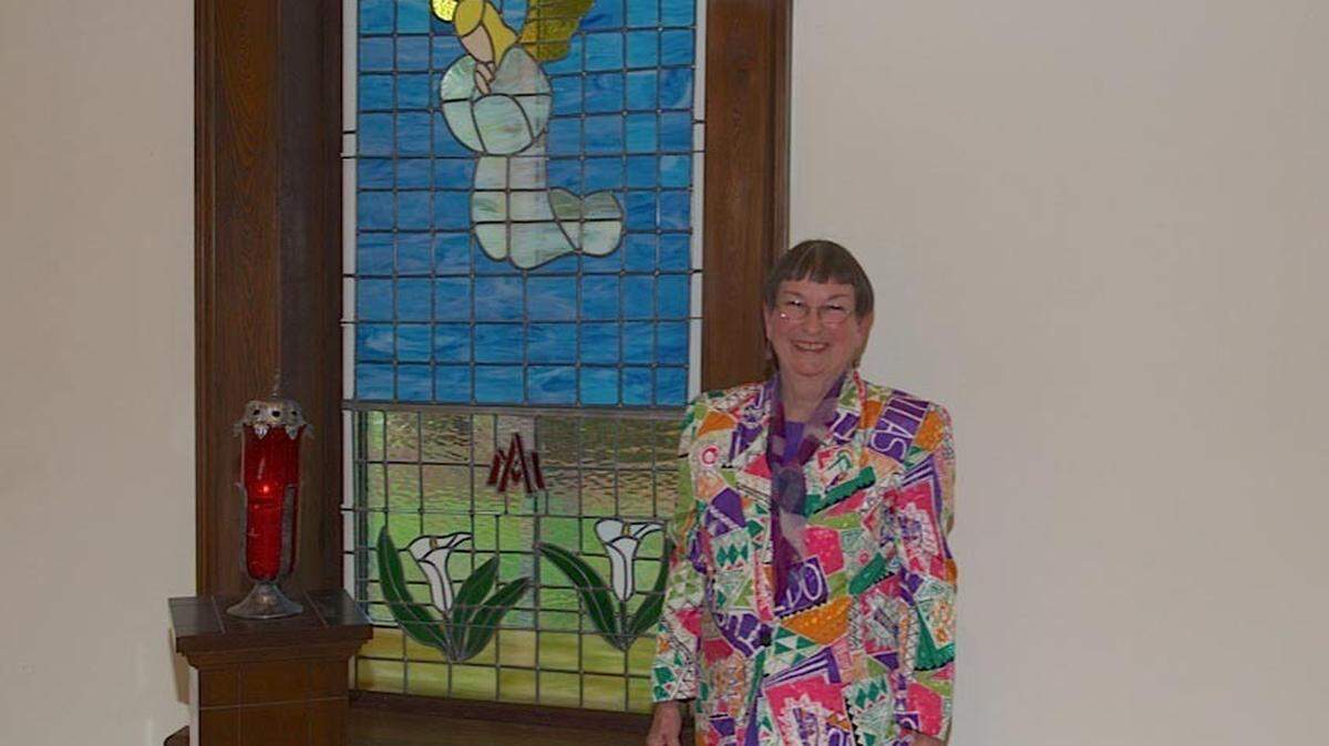 Emily O'Brien of Beaufort stands with the stained glass windows she made for the Our Lady's Adoration Chapel at St. Peter's Catholic Church on Lady's Island.