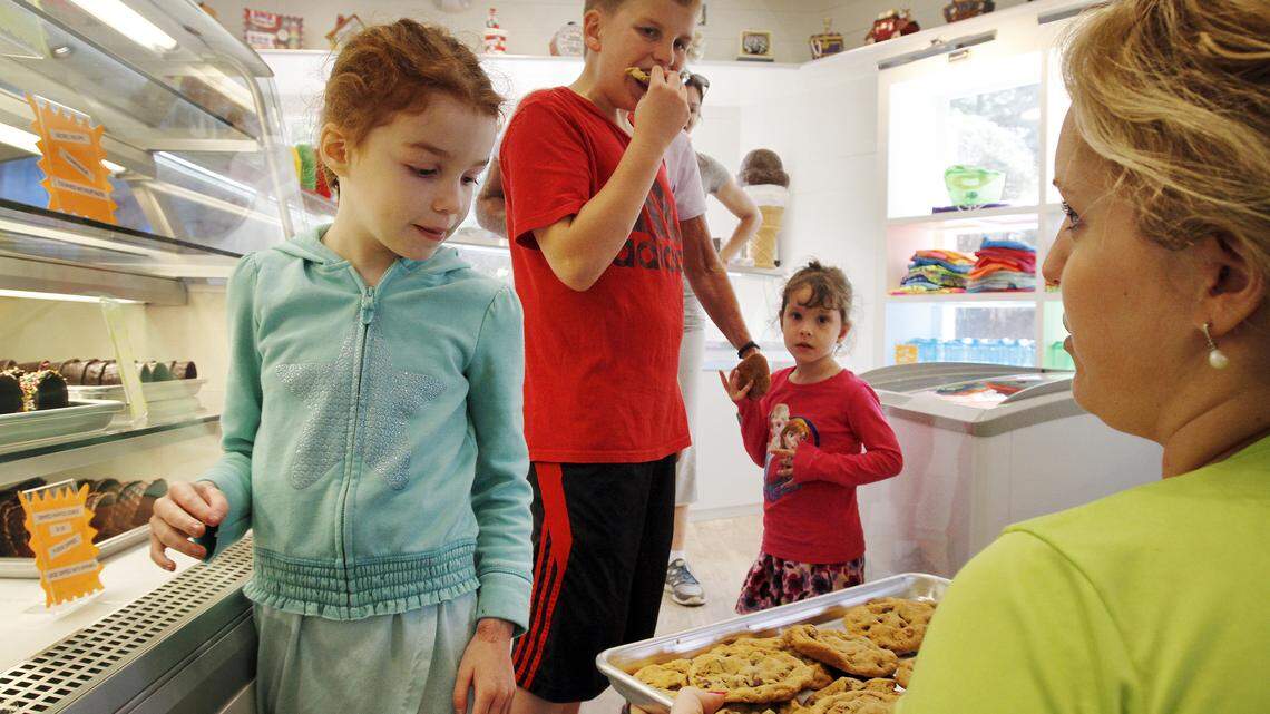 Kate Knisely, owner of Hilton Head Ice Cream, in Fountain Center at 55 New Orleans Road, Suite 114, on Hilton Head Island, serves cookies, made scratch from a family secret cookie recipe to Olivia Catarello, 5, of Illinois, left, Kaden Vanschelven, 11,  of Illinois, center, and Claire Vanschelven, 3,  of Illinois, center right, during the soft opening on April 2, 2015. Hilton Head Ice Cream, which has been open since 1982, has gutted out and completely renovated its shop.  
To watch a video, go to:?http://bit.ly/1gf1c6W 
To see more photos, go to: http://bit.ly/1hgaxhj