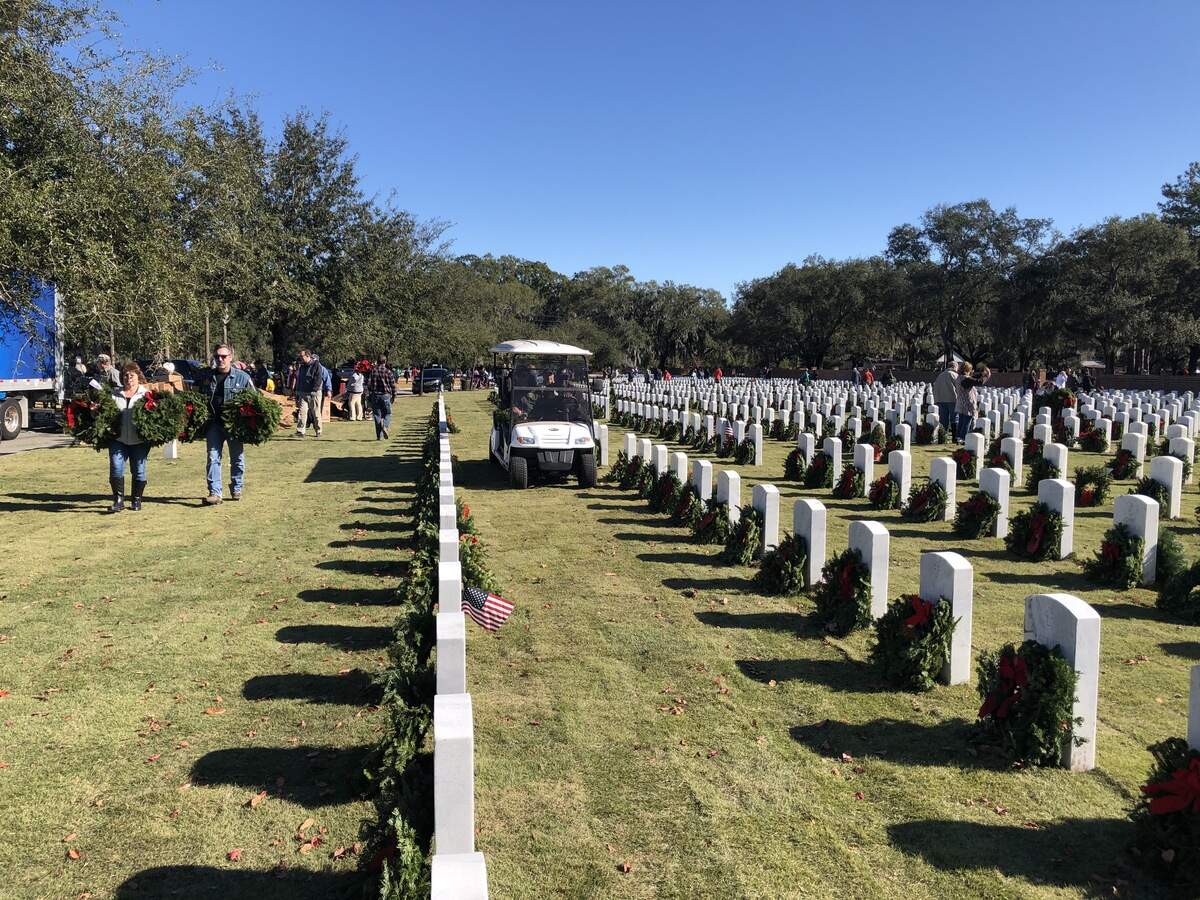 Volunteers place wreaths at headstones in the Beaufort National Cemetery on Saturday.