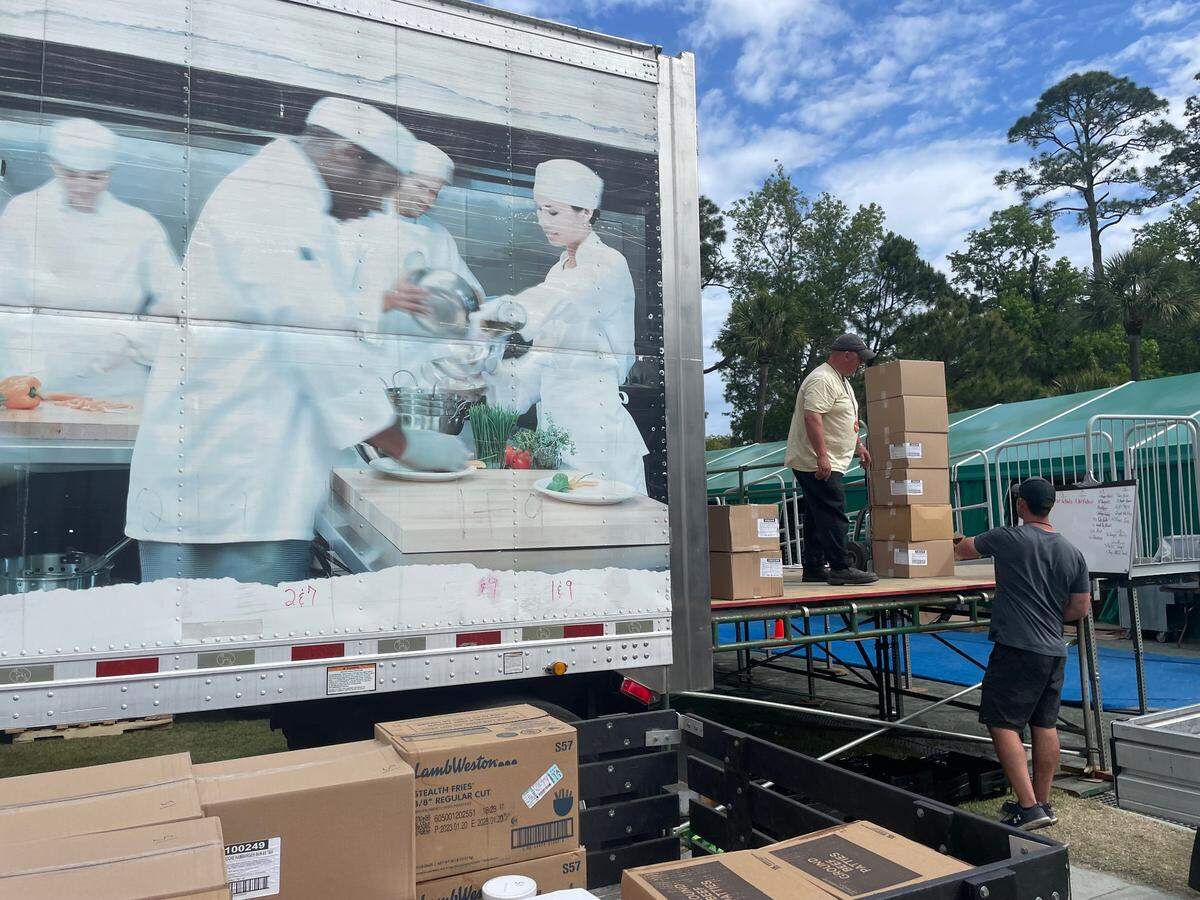 Food is loaded off refrigerated trucks and onto golf carts to deliver to concession stands.