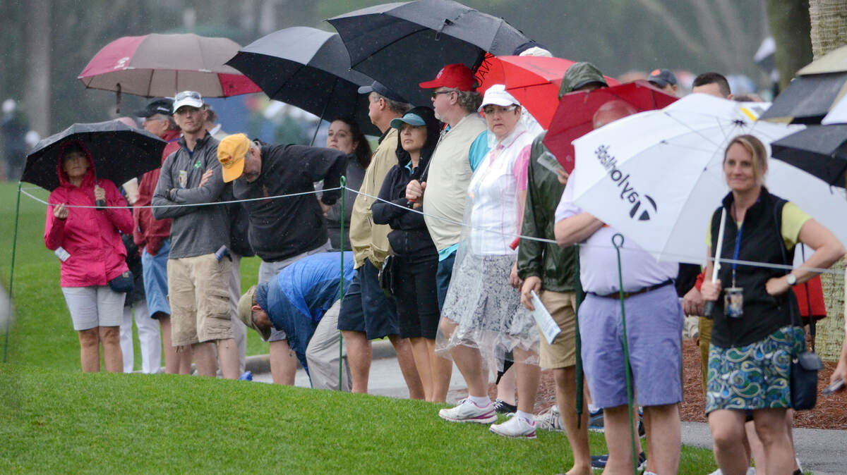 Golf fans wait in the rain for a glimpse of their favorite player at the first tee during the final round of the RBC Heritage Presented by Boeing golf tournament, held on Sunday, April 19, 2015 at Harbour Town Golf Links on Hilton Head Island, S.C.