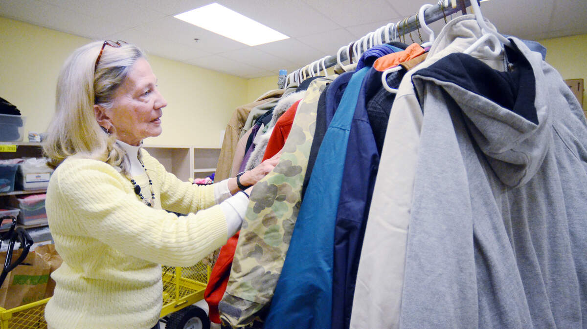 File: Executive director Betsy Doughtie looks through some coats at Deep Well on Jan. 6, 2015. The charity has a good supply of warm clothing, blankets and space heaters available for its clients during the coming cold snap.