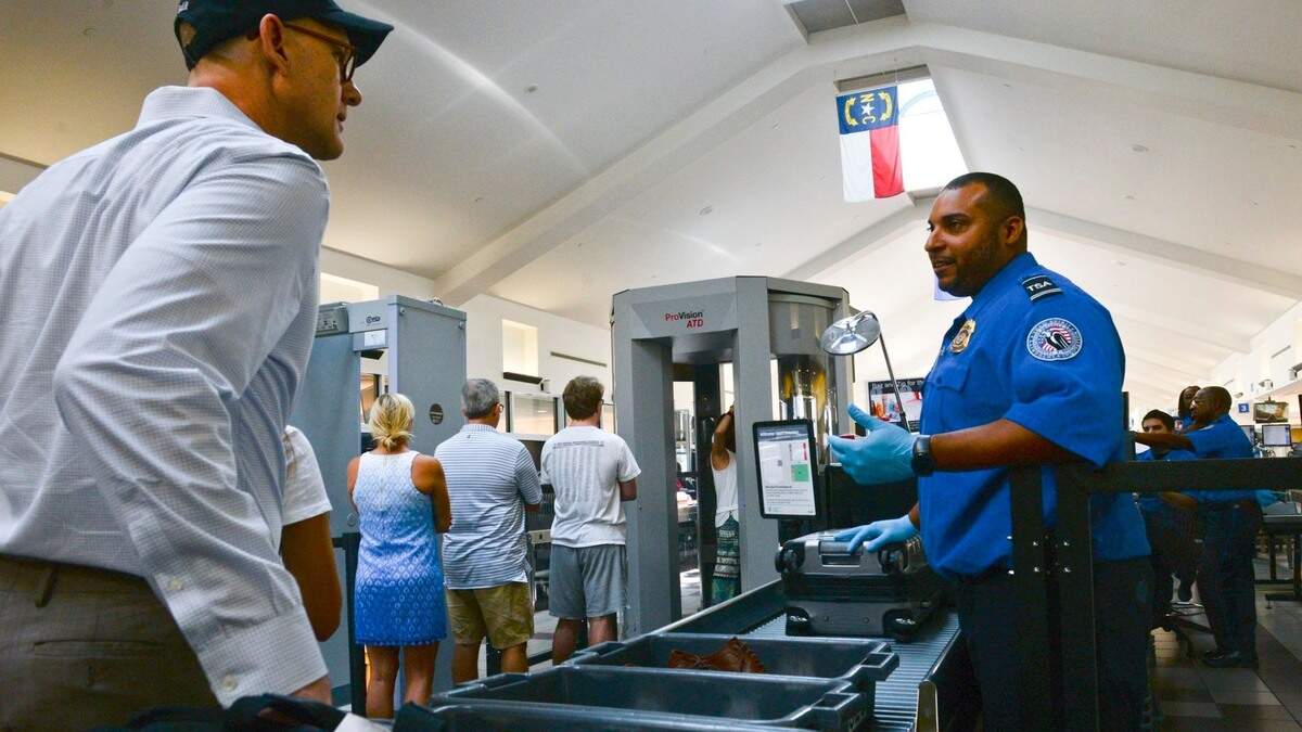 In this file photo Savannah/Hilton Head International Airport TSA Lead Officer Darrell Wade talks to passengers as they make their way through the TSA checkpoint on Aug. 9, 2018.