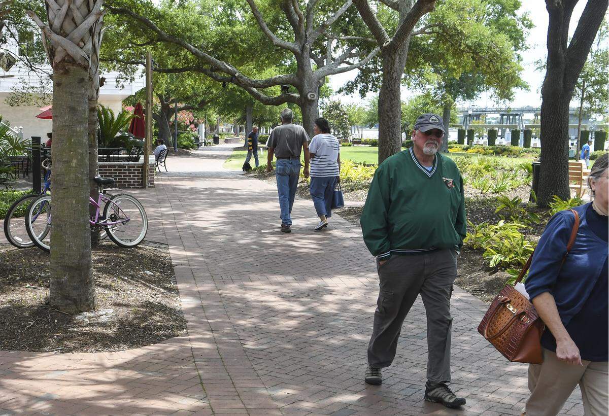 Couples walk in the shade cast by the live oaks in Henry C. Chambers Waterfront Park on Tuesday, May 12, 2020 in Beaufort’s Historic District.