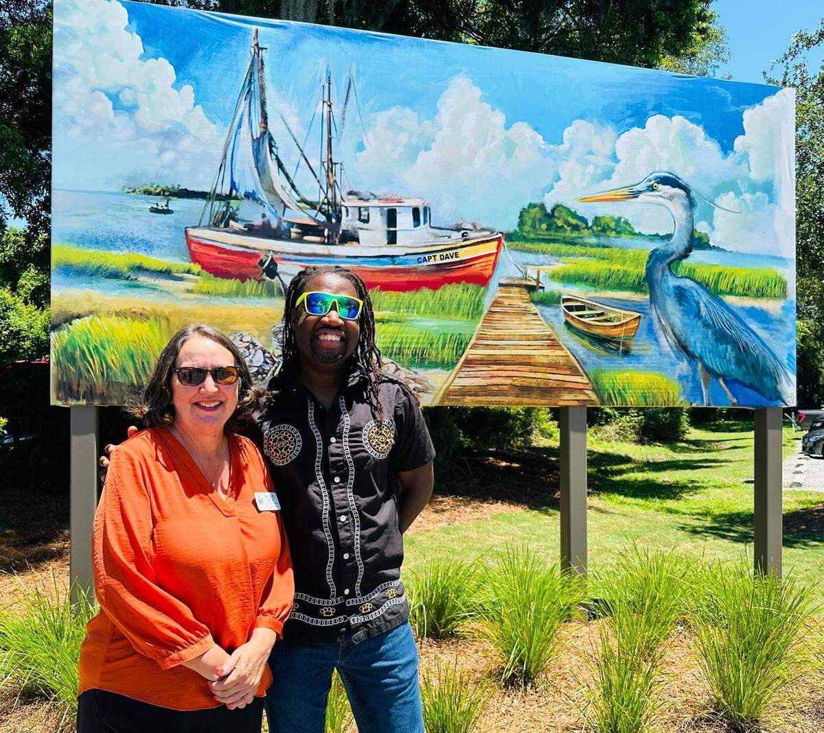 Natalie Harvey, director of the Town of Hilton Head Island’s Office of Cultural Affairs, left, and artist Amari Farris pose at his mural honoring the environmental and economic legacy of the Hilton Head Fishing Cooperative. The mural was unveiled May 22 at the Rowing & Sailing Center at Squire Pope Community Park on Squire Pope Road.