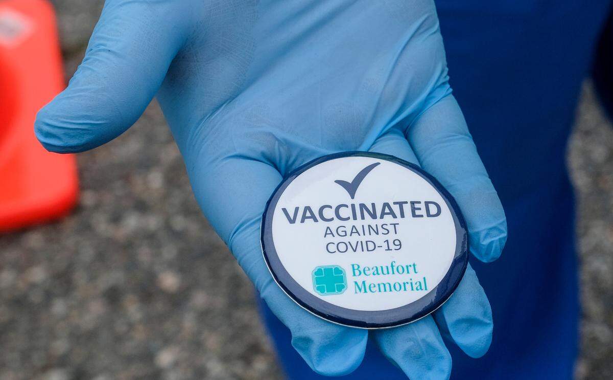 Registered nurses with Beaufort Memorial Hospital handed out buttons on Thursday, Jan. 21, 2021 to those who received their first dose of the Pfizer-BioNTech vaccine at a drive-thru clinic in the parking lot of the Beaufort High School stadium.