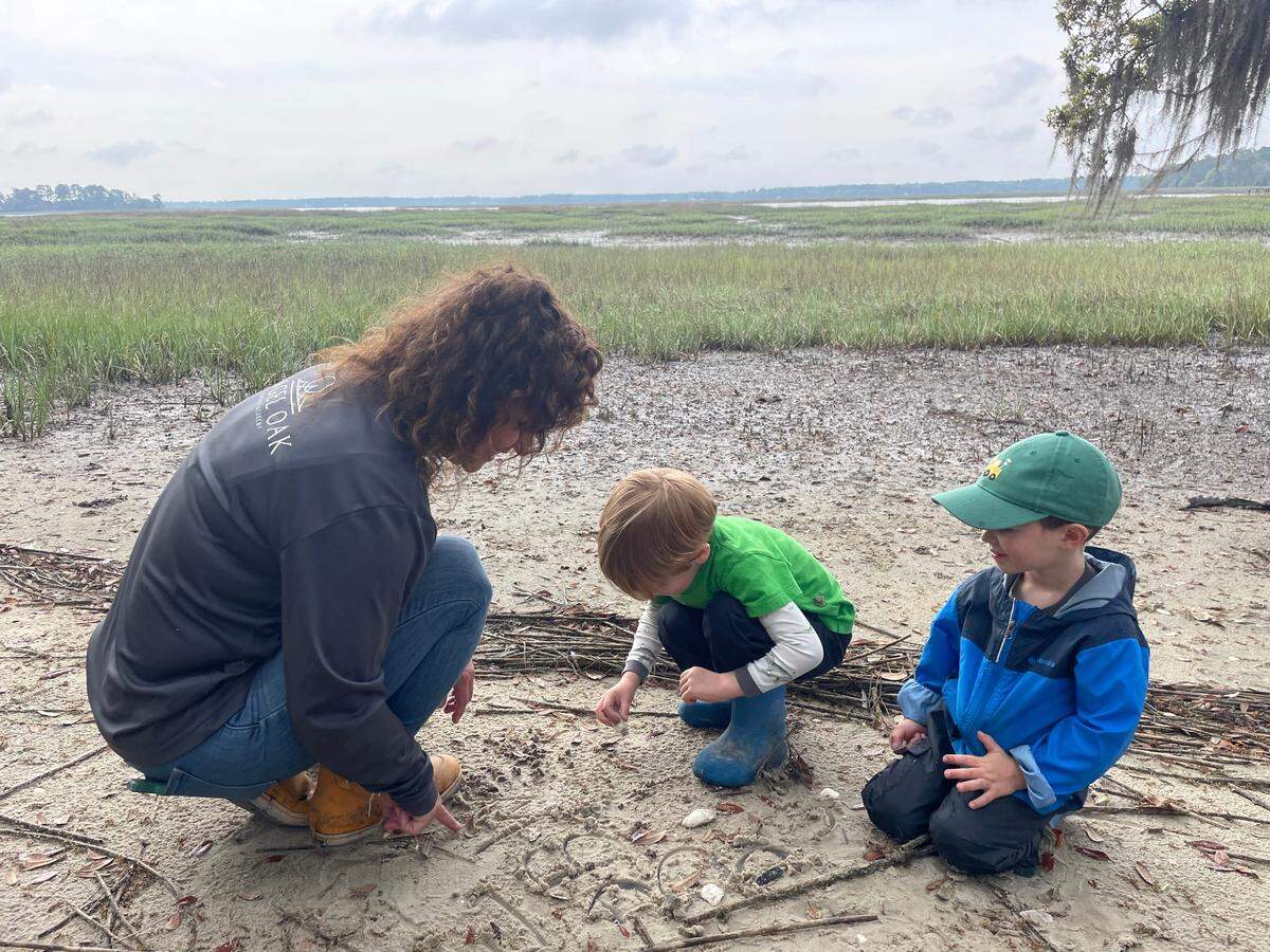Angel Oak Nature Academy students practice letters in the sand.