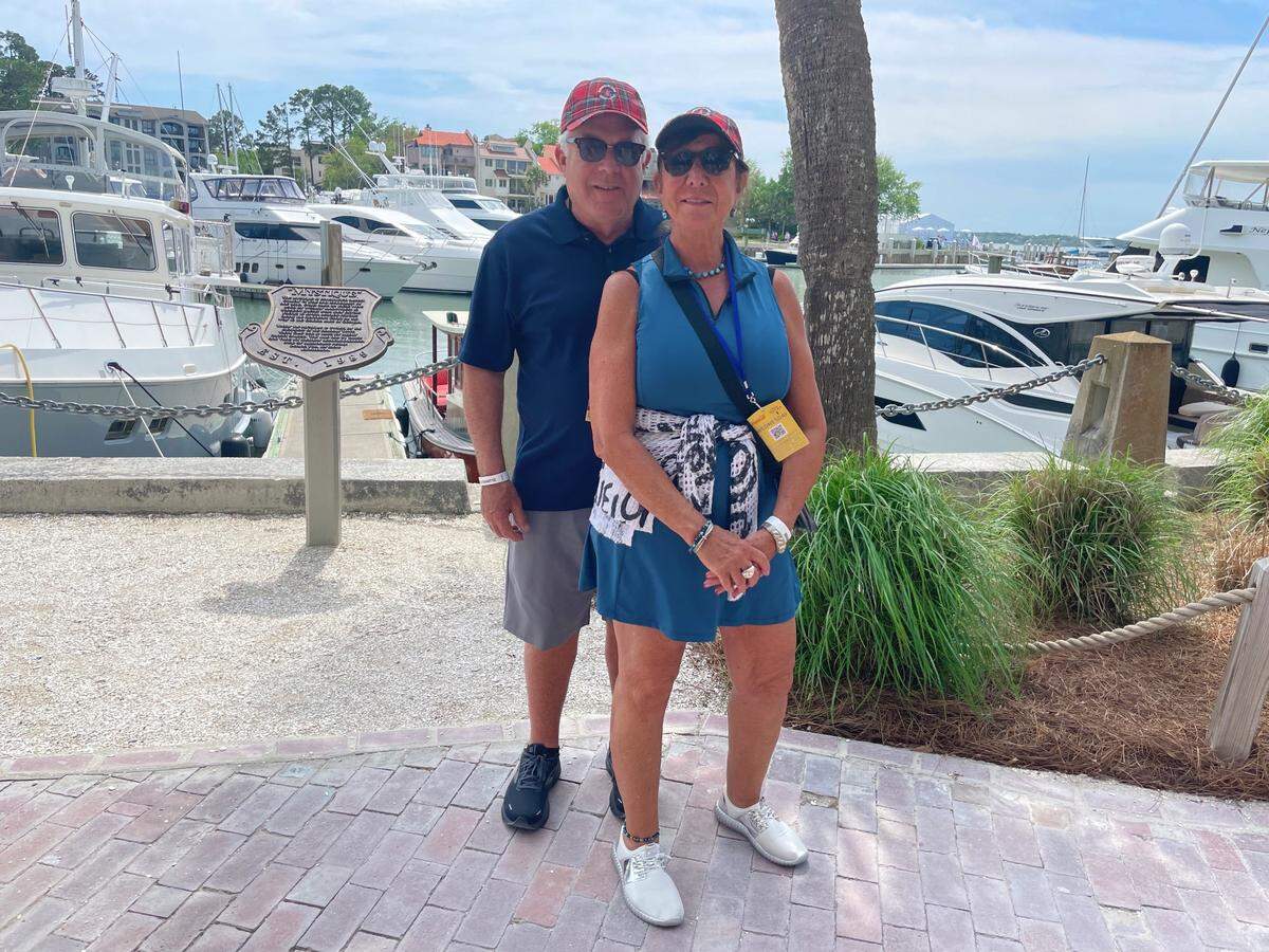 Rena Laban and John Test sport Harbour Town Golf Links ball caps in red tartan during the 2022 RBC Heritage tournament.