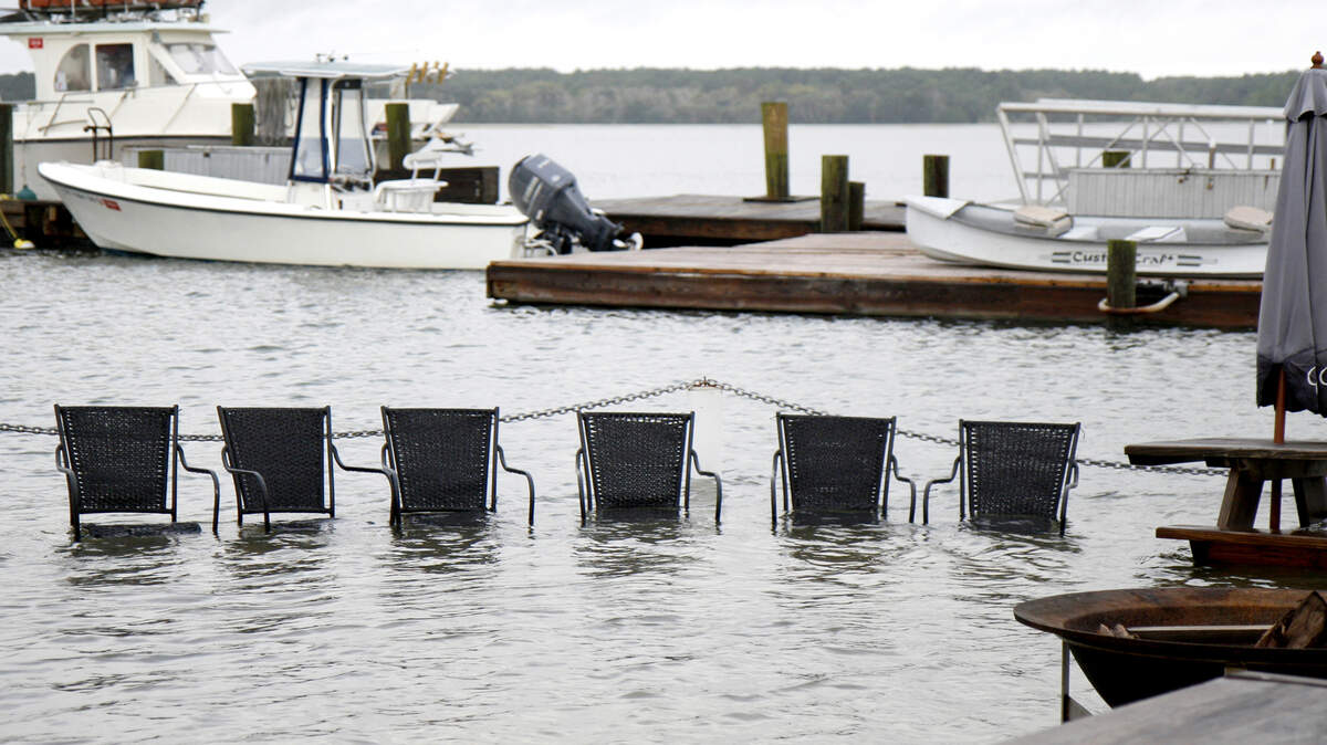 Chairs sit submerged on the outside patio at Hudson's Seafood on Hilton Head Island after a king tide the morning of Oct. 28. Andrew Carmines, the restaurant's owner, says the day's high tides were not nearly as bad as the previous morning, where the water came into the room but receded in time for lunch.