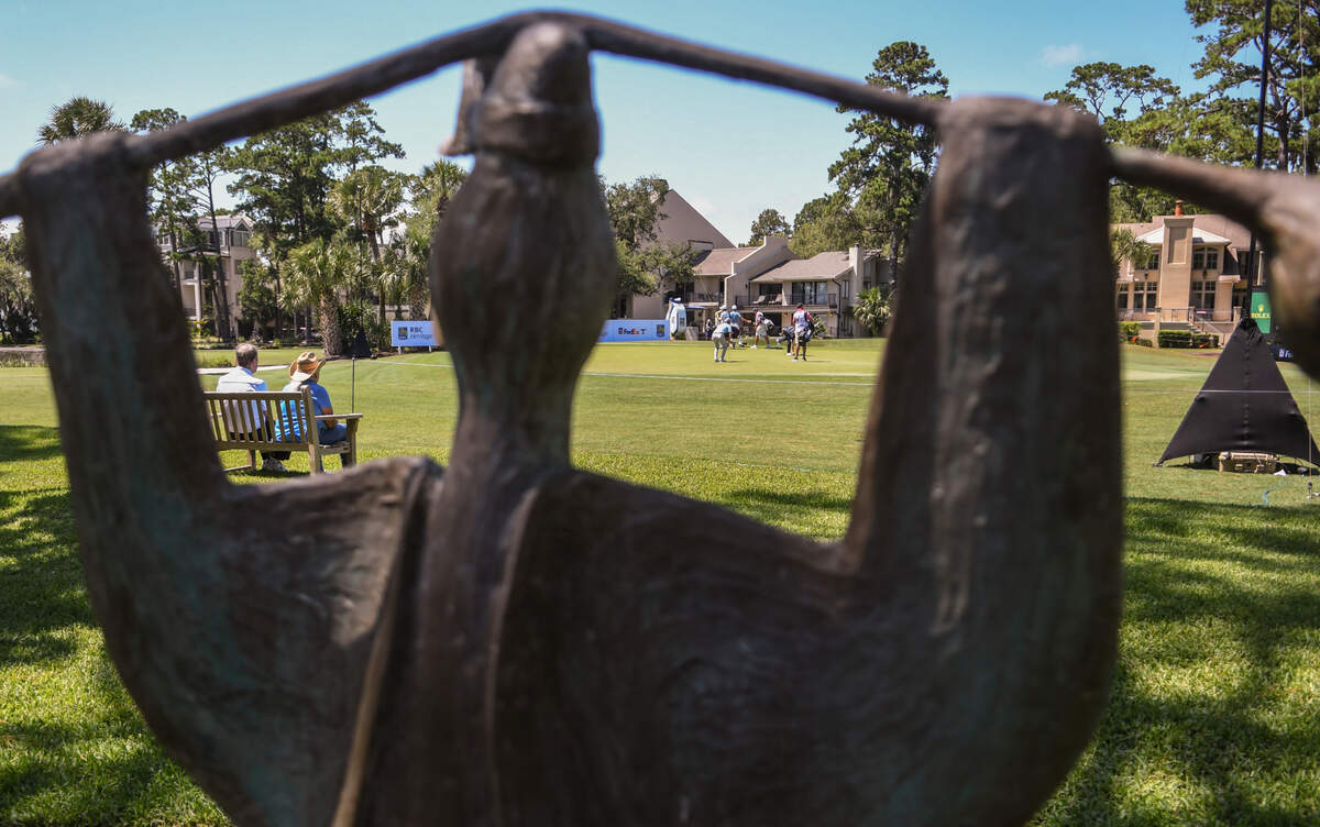 Looking through the wings of a Walter Palmer “I love the game” bird sculpture sits Jack and Velma Docherty in their yard at the green of the 16th hole of Harbour Town Golf Links on Thursday, June 18, 2020, as they watch a grouping of PGA Tour pros play in the first round of the RBC Heritage in Sea Pines on Hilton Head Island.