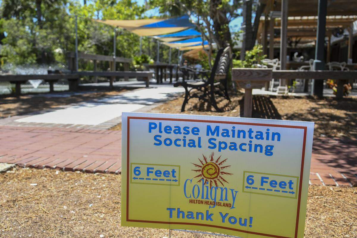 A sign in Coligny on Hilton Head Island reminds people to maintain their social distance as the outdoor dining area at Fish is seen in the background. While the restaurant chose not to open inside dining, Monday marked the first day restaurants could have indoor seating at half the capacity after SC Governor Henry McMaster relaxed some of the rules on closures he enacted to stop the spread of the coronavirus.