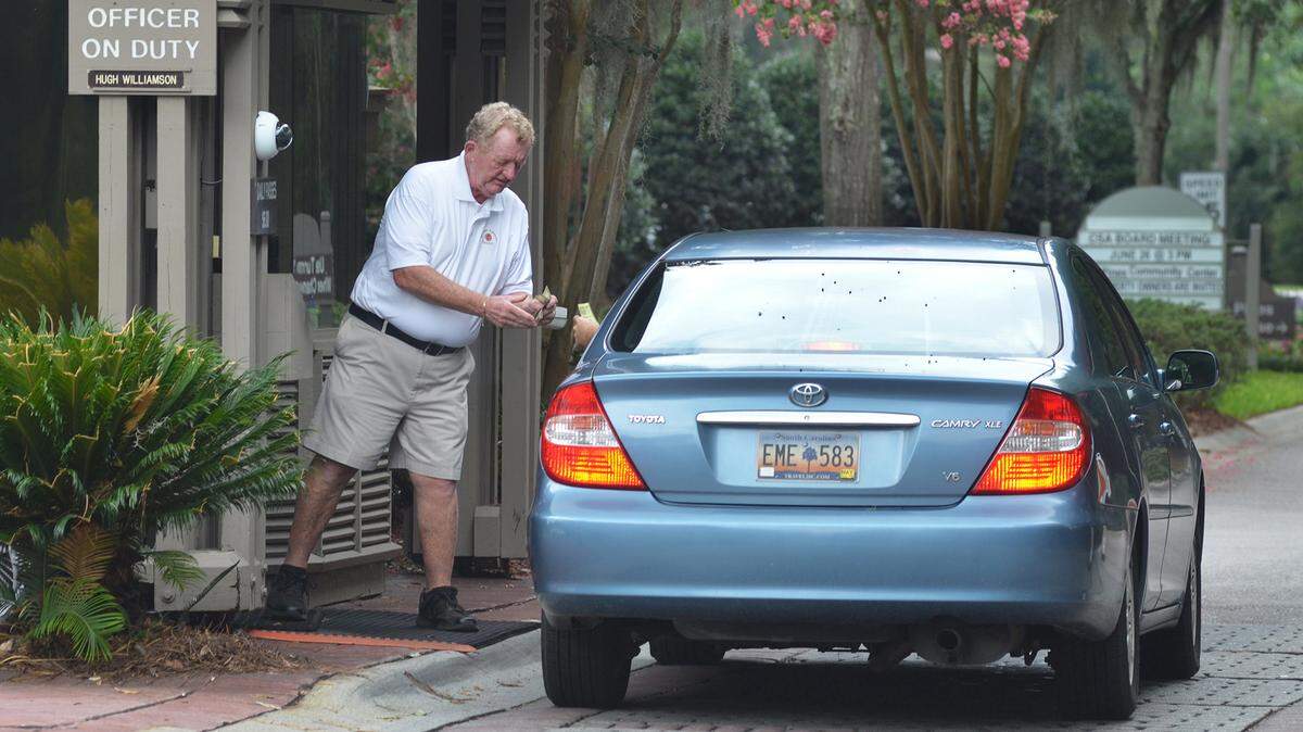 In a 2018 file photo, Sea Pines security officer Hugh Williamson collects the entry fee for a day pass into Sea Pines from a motorist at the Greenwood gate. Sea Pines officials are considering eliminating a practice than has allowed short-term rental guests to purchase $20 weekly passes at the gate.