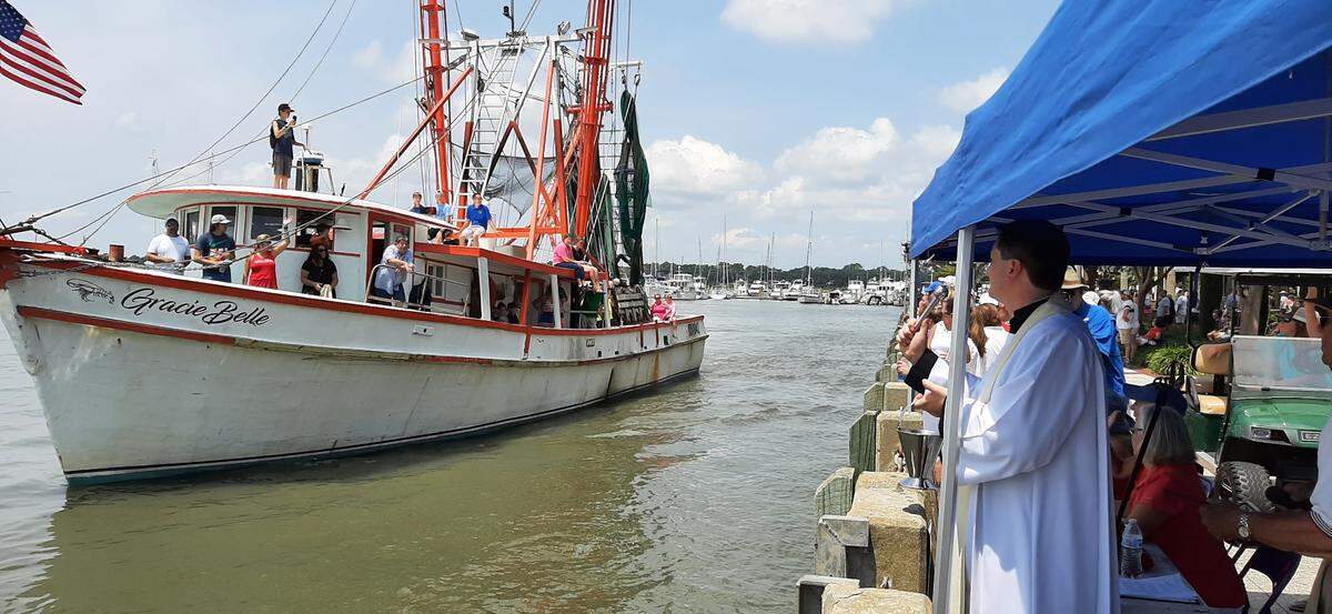 Father Andrew Trapp blesses the Gracie Belle, a shrimp boat, Sunday, the final day of the Beaufort Water Festival.