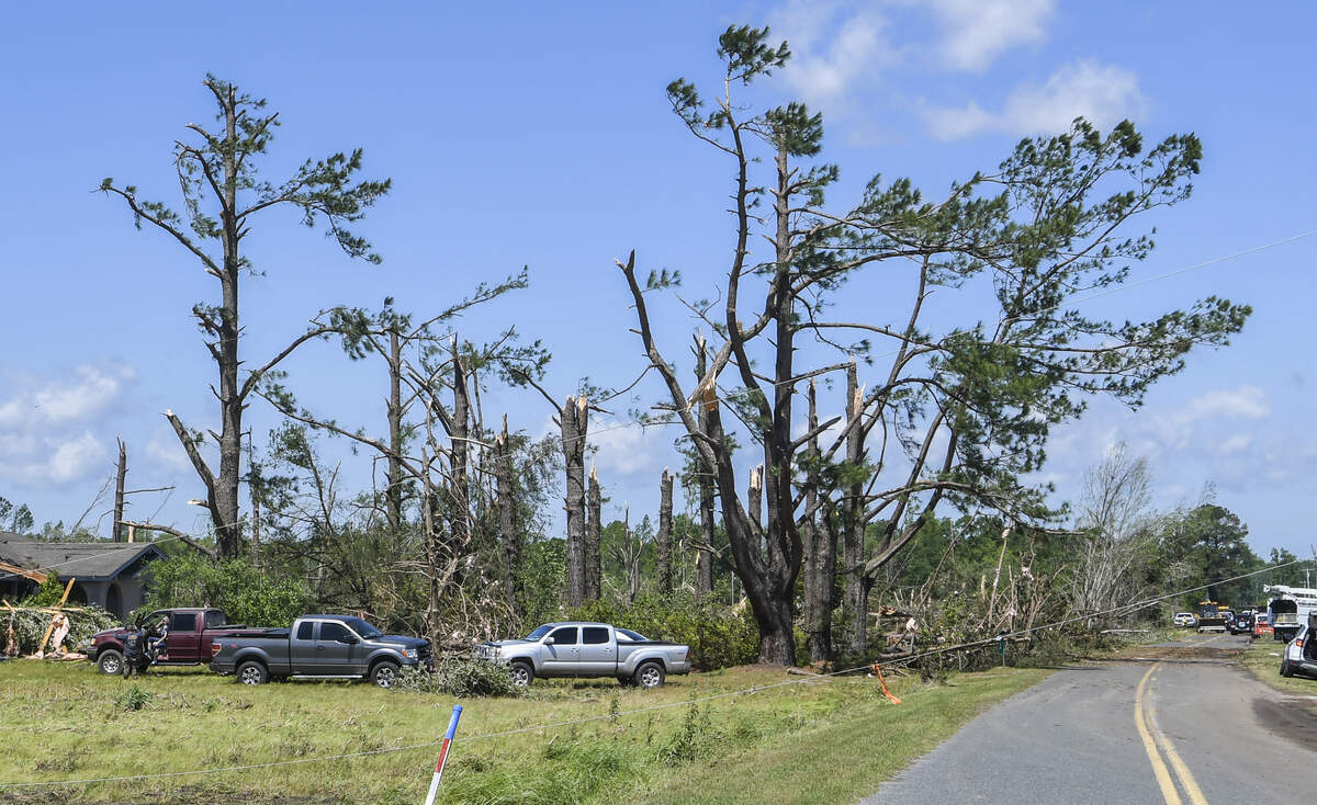 A power line stretches over a road in Lena, South Carolina on the morning of Monday, April 13, 2020, after a tornado ripped through the town, toppling homes and snapping trees in its path.