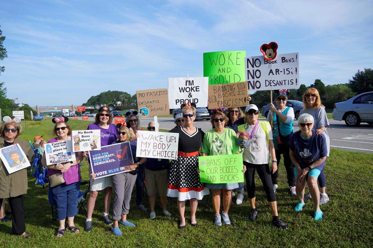 A throng of mouse-eared protesters display their signs along U.S. 278 during Ron DeSantis’ Friday morning campaign stop in Bluffton.
