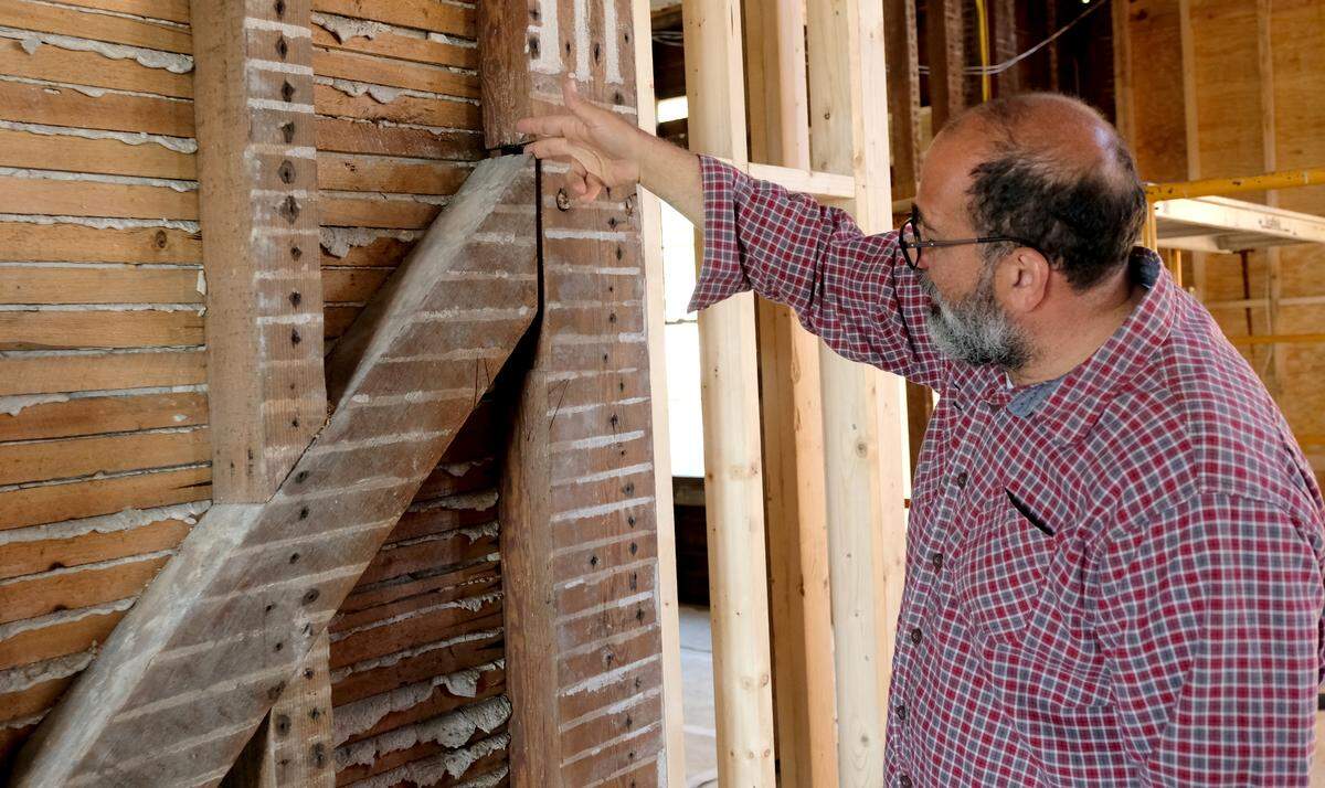 Arthur Aquilato, the developer's representative of Tidalholm, places his finger Thursday morning in between a joint to show how carpenters used wood joints to make connections for the home that was built in 1853, well before the creation of power tools.