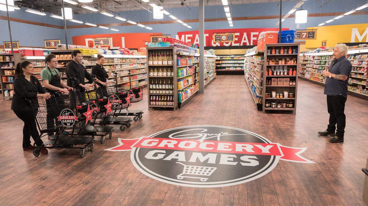 Contestants listen as host Guy Fieri explains the rules on a Season 14 episode of “Guy’s Grocery Games” on Food Network.