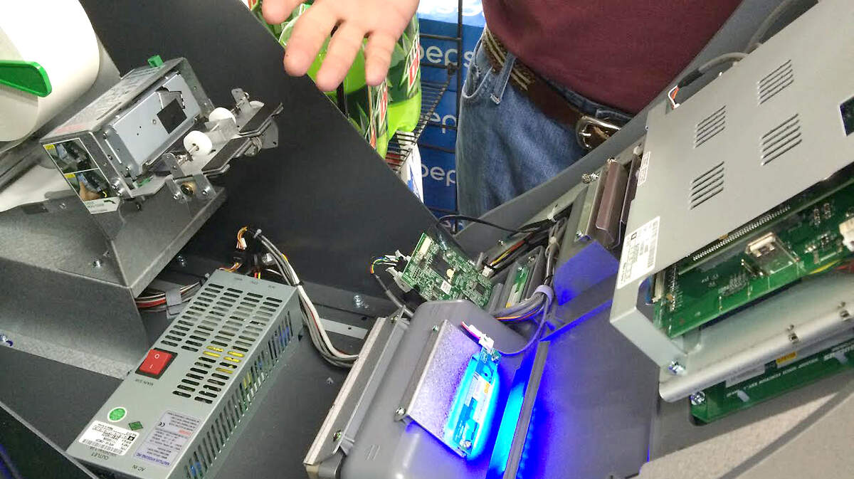 Nickey Maxey, a Bluffton gas station owner, uses a generic service key to open the ATM inside his Shell station on Plantation Park Drive on April 28, 2015.  Maxey says his machines are checked daily to load paper for receipts and that any tampering to the machine would be obvious.
