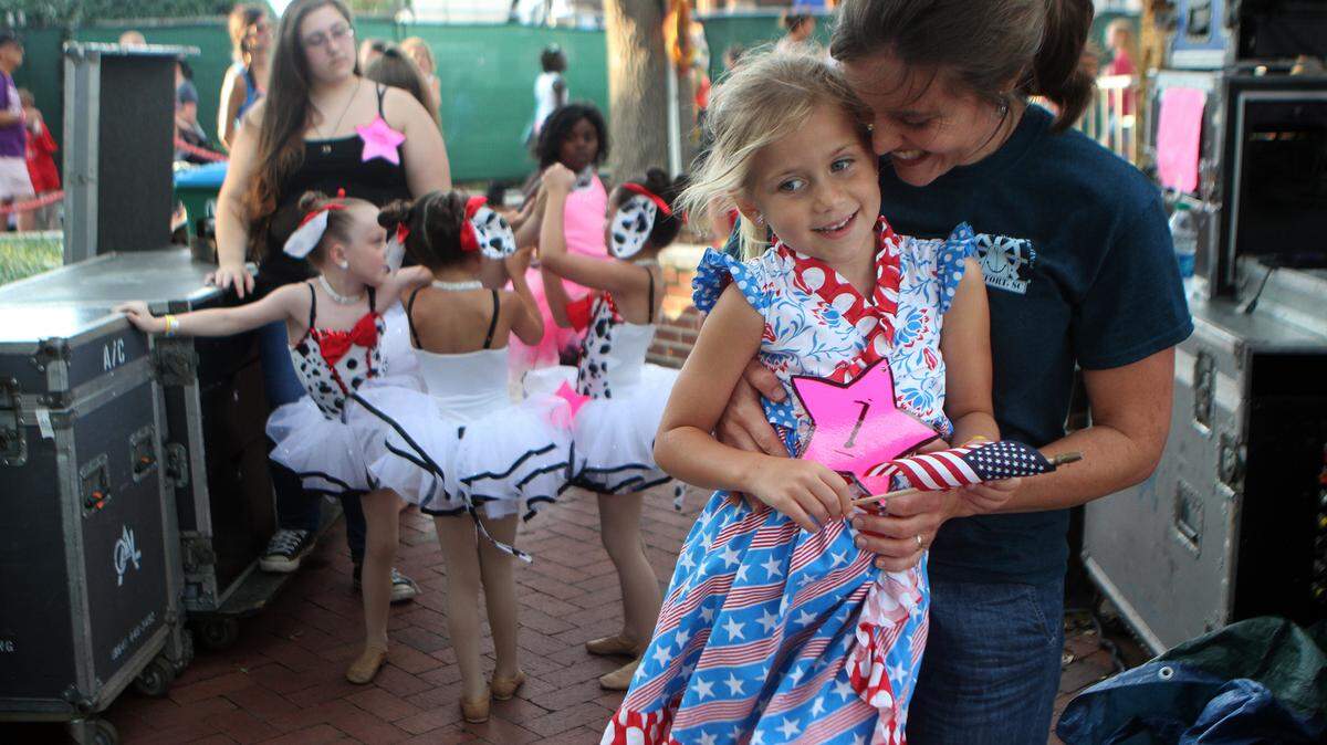 Amy Wilson hugs her daughter Belle, 6, while waiting backstage before for her to sing "God Bless The U.S.A.," during the Talent Show on Wednesday night during the 60th Annual Beaufort Water Festival at Henry C. Chambers Waterfront Park in Beaufort.  Belle has wanted to sing in the Talent Show since she was 3 years old and always knew that she wanted to sing the patriotic song.  "I just love the music in it," Belle said.