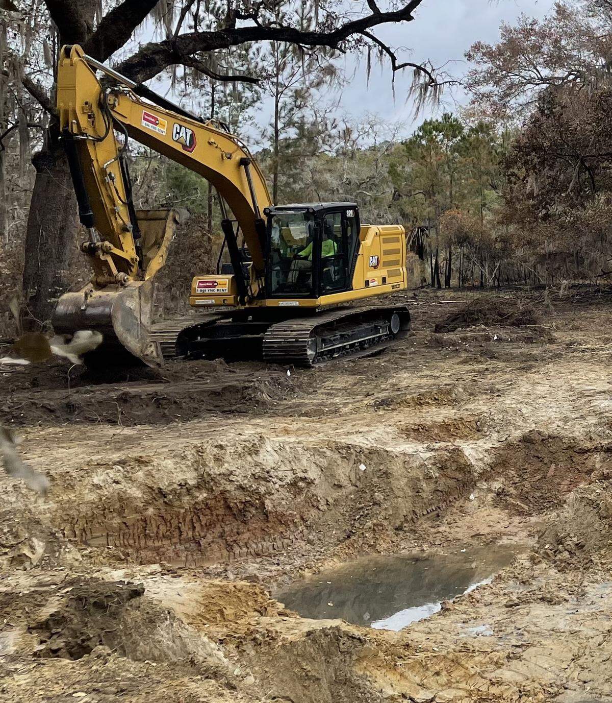 U.S. Navy contractors are seen removing soil containing jet fuel. Next, the team will bring in clean backfill soil to restore the impacted property.