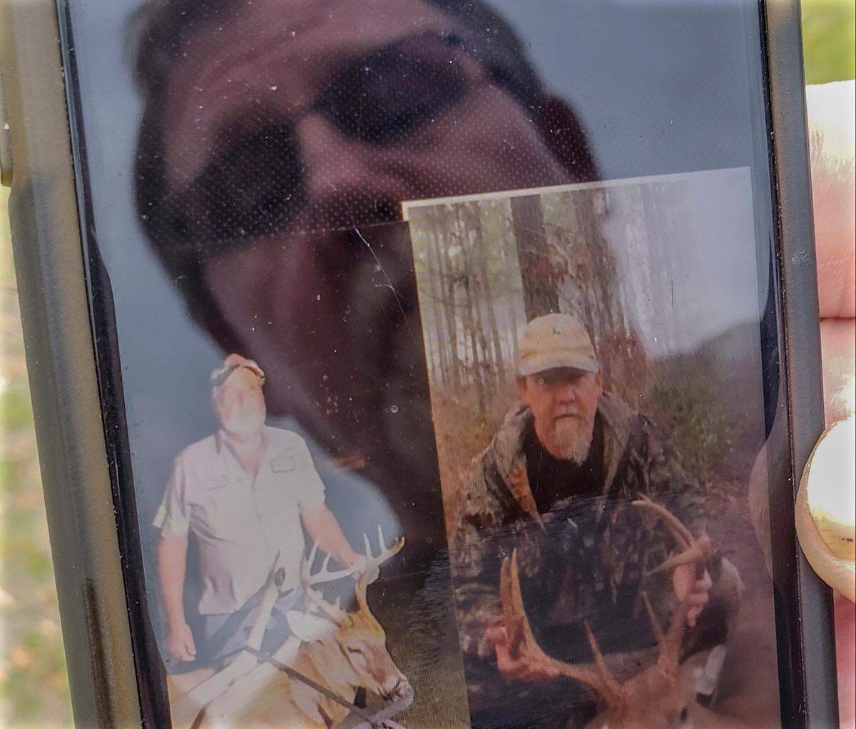 Keith Pauls reflection is seen in his smartphone as he displays a photo collage on Tuesday, March 30, 2021 he created of his best friend and hunting partner, Jim Breland, lower left, and himself at Pauls’ Nixville, S.C.home. Jim Breland, his wife Donna and their daughter Kayla died in the early morning hours of April 13, 2020 when a EF4 tornado made landfall.