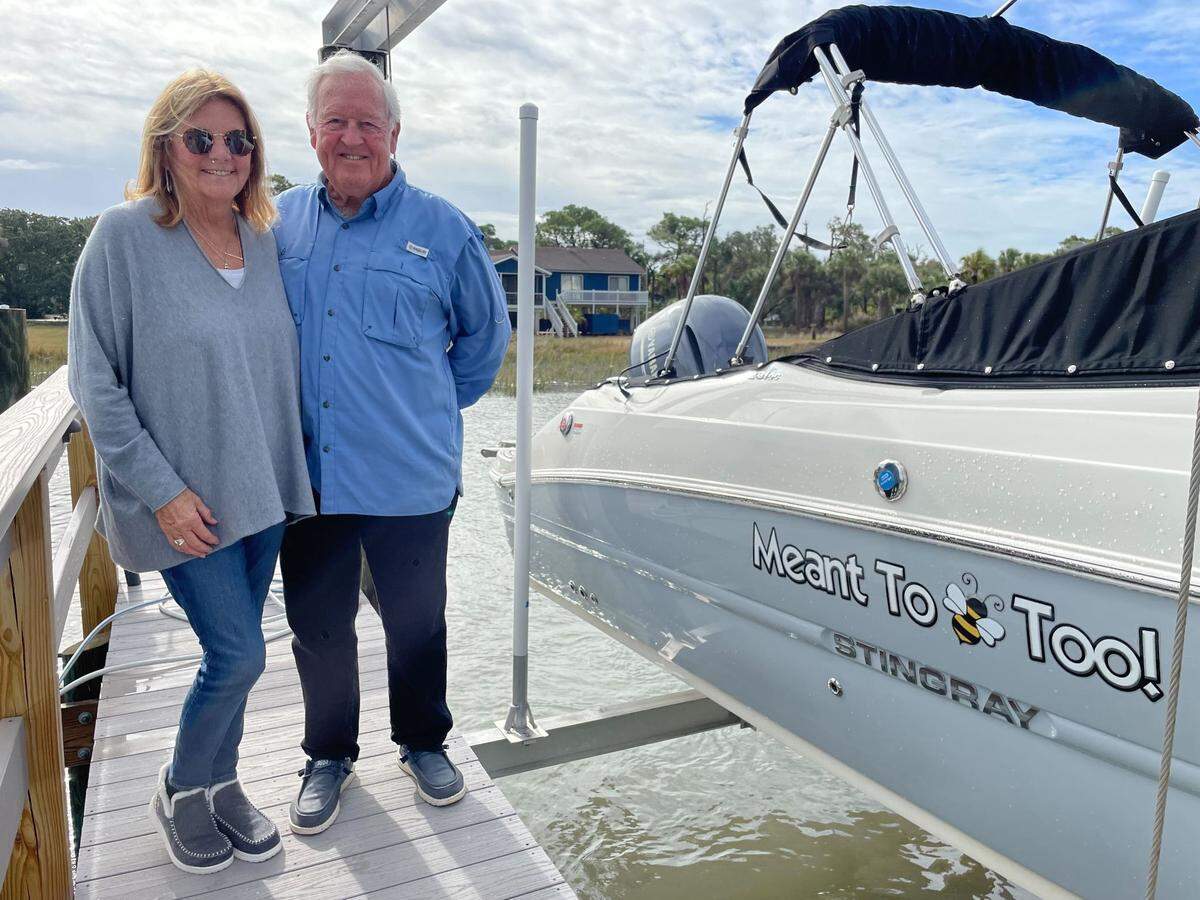 Don and Lori Peel standing next to their boat, which was named to match their home name: “Meant to Bee.”