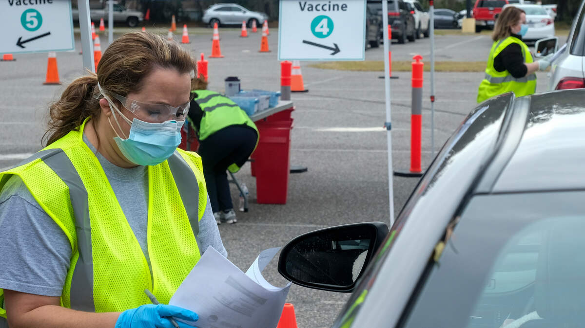 Before administering the Pfizer-BioNTech’s vaccine, Summer Cook a Registered Nurse in the emergency department at Beaufort Memorial Hospital, goes through questions with a vaccine recipient on Thursday, Jan. 21, 2021 in the parking lot of Beaufort High School’s stadium. Thursday marked the first drive-thru clinic for vaccine administration in Beaufort County.