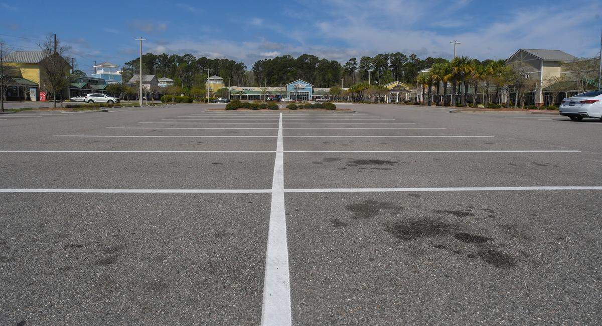 An empty Tanger 1 parking lot is seen on Thursday, March 19, 2020, a day after S.C. Gov. Henry McMaster closed indoor service to restaurants and bars. The majority of national retailers and small businesses at the outdoor mall had signs saying they have reduced hours or would be closed until the end of the month. Mike Racanelli, owner of Teak + Table, said his store and about six others have remained open.