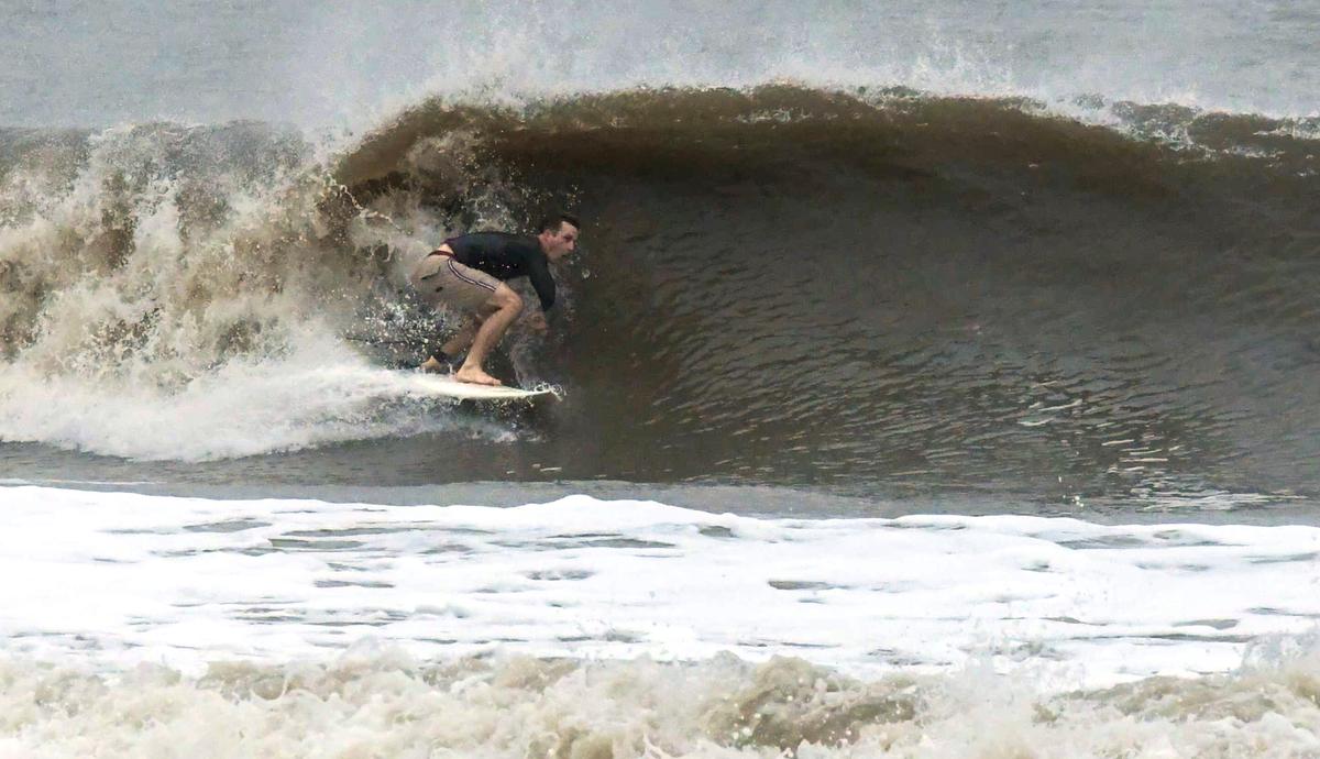 A surfer enjoying the waves created by Hurricane Ian on Hilton Head Island as it came ashore in South Carolina on Friday, Sept. 30, 2022