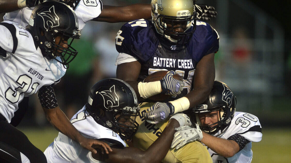 Battery Creek's Alterell Chatman holds tight to the ball as Bluffton's Charles Barron, bottom left, Jabriel Robinson, top left, Kevin Diggs, center, and Dylan Lapinski, right, try to tackle him during their game on Friday night at Battery Creek High School in Beaufort.