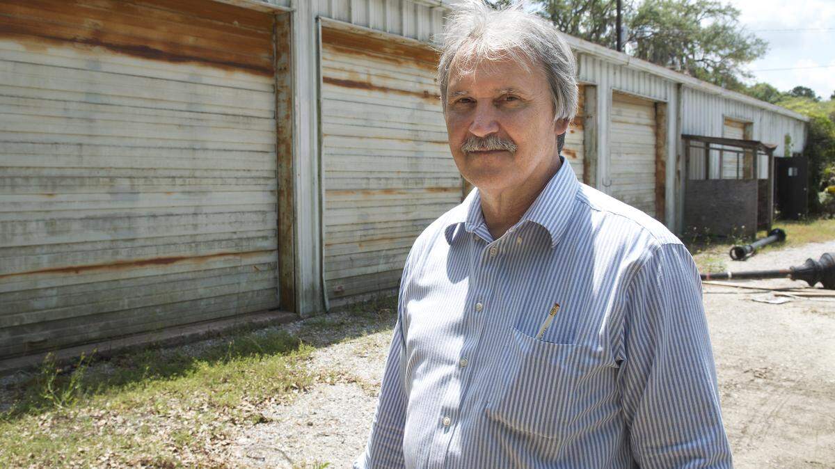 Paul Brody stands Friday afternoon in front of one of two buildings that would be re-purposed for the Beaufort Community Farm he is proposing for Beaufort\'s Southside Park. Brody said he would use the building as and office and market, replacing the garage doors with wooden doors similar to a barns swing doors.