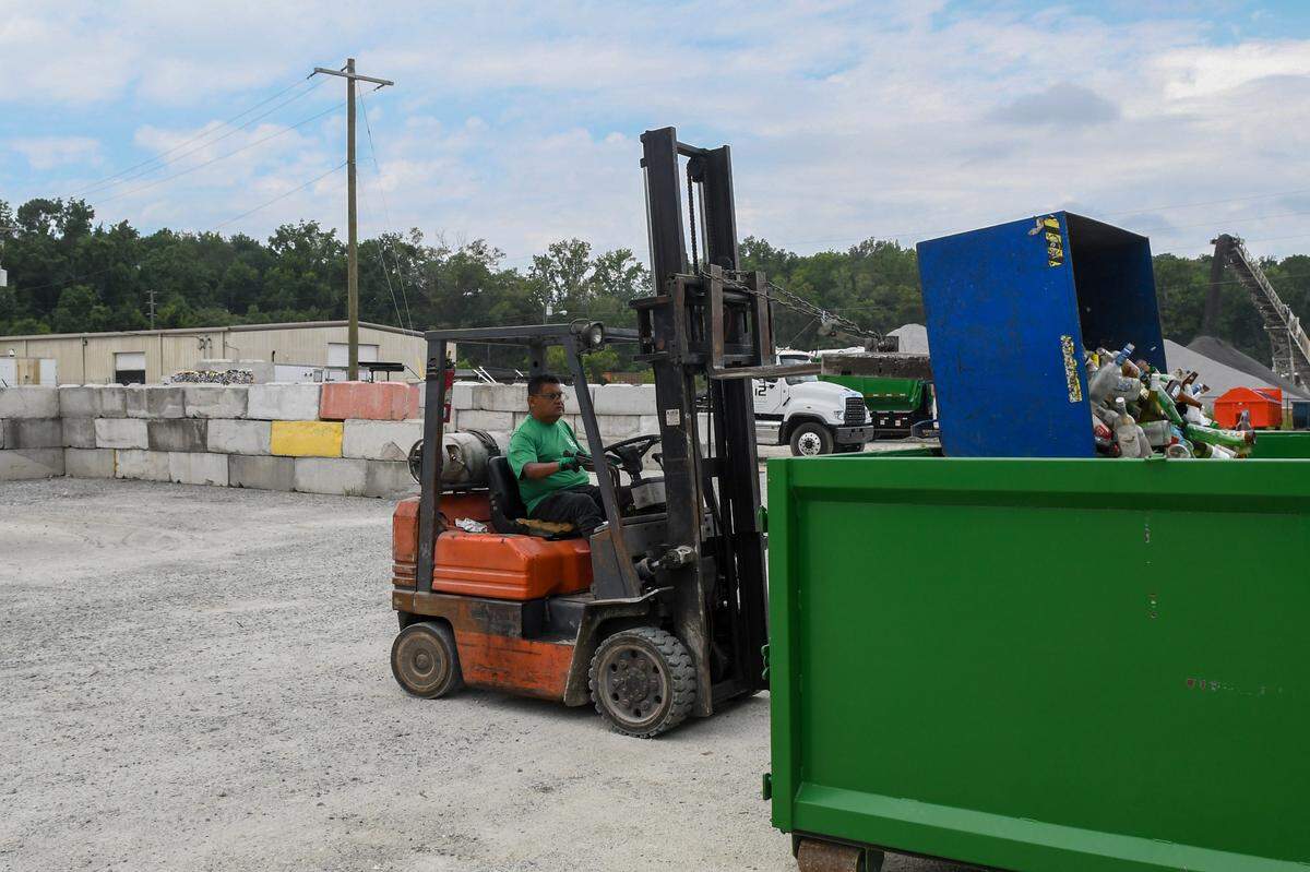 A worker empties sorted glass into a bin on July 12, 2024 at i2recycle located in the Hardeeville Industrial Park in Hardeeville, S.C.