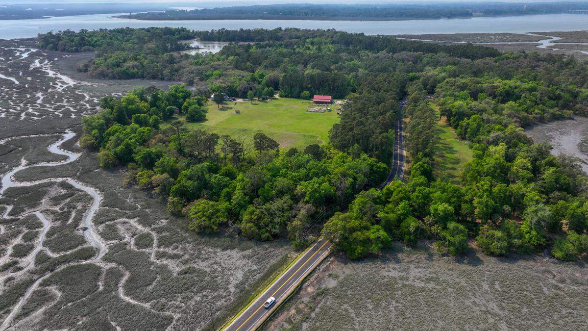 A vehicle travels to Lower Cane Island on the Islands Causeway over the marsh from Cat Island on April 16, 2025, in Beaufort County. A preliminary rendering for development shows the visible, open green space be developed with a restaurant, an event barn and meeting space. The plan also shows residential lots along the marshfront, with numerous docks extending into the marshes with waterways that may no longer be navigable by boats.