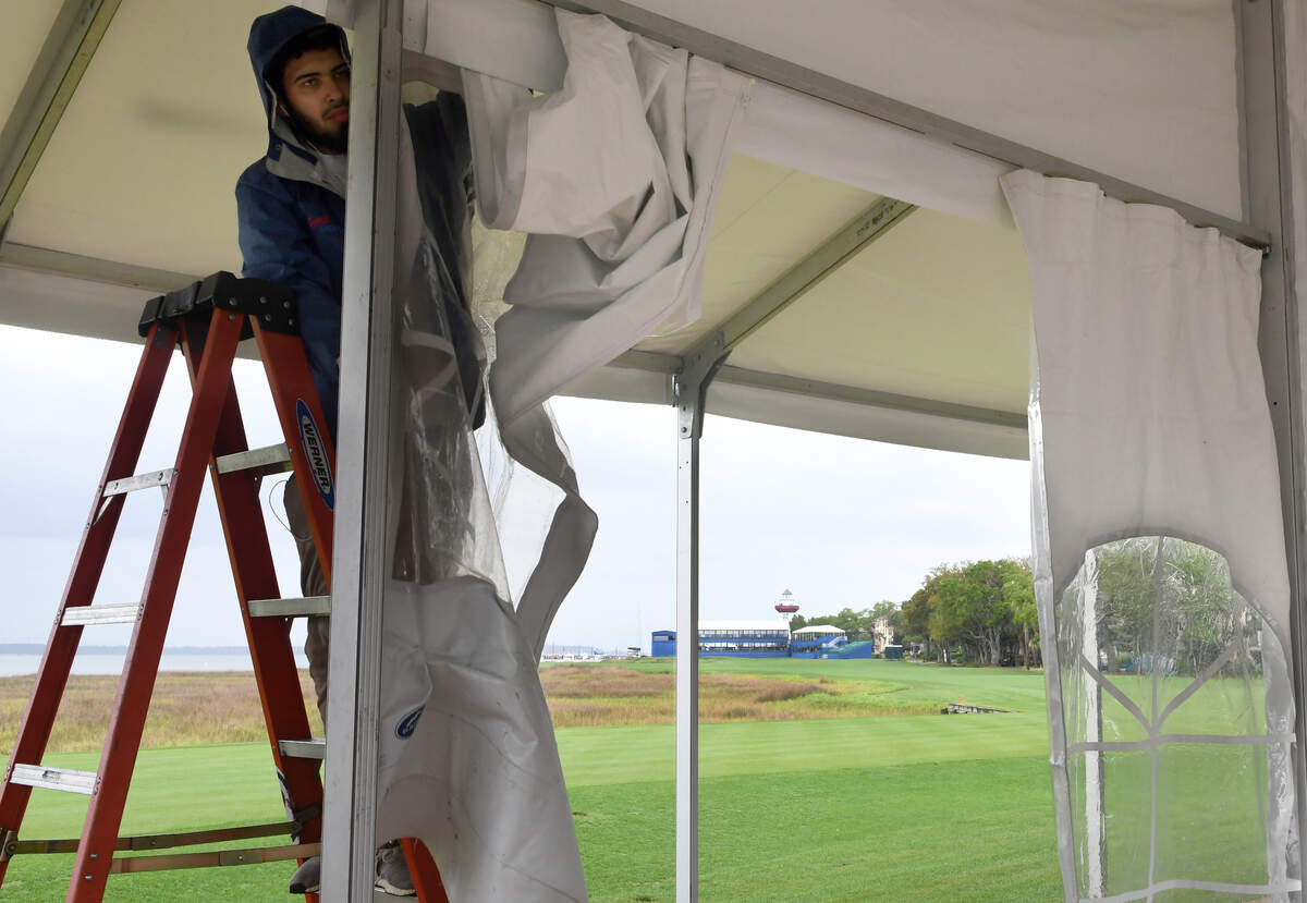 Amid intermittent rain showers, Shannon Kanniard, with Ohio-based Sports America, installed plastic walls for luxury booths in 2018 near Heritage Lawn with Harbour Town’s signature lighthouse rising in the background.