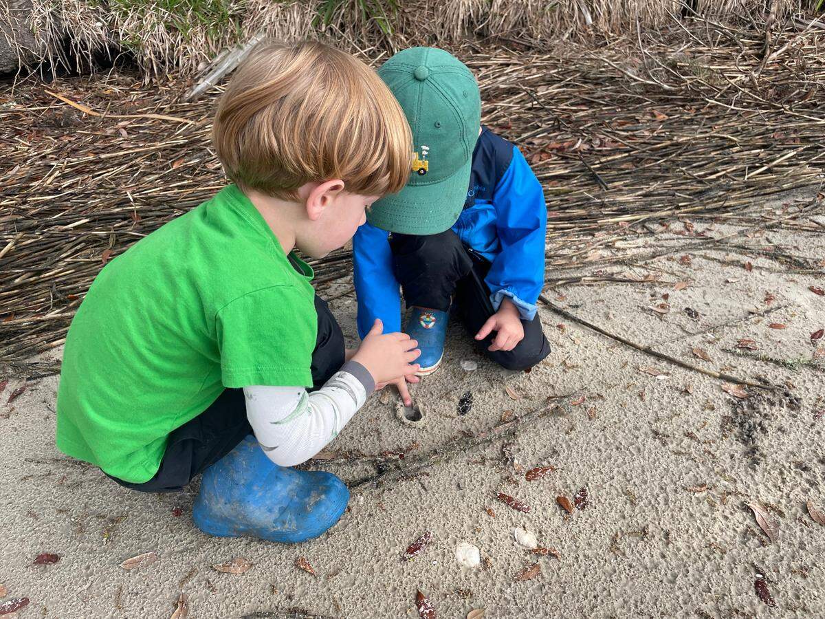 Two Angel Oak Nature Academy students play in the sand.