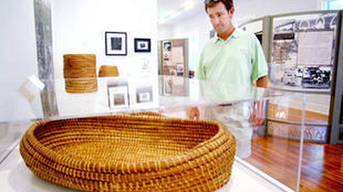 9/14/10 Jay Karr/The Island Packet--Erik Stevens looks at his sweetgrass basket on display at the Coastal Discovery Museum in September.