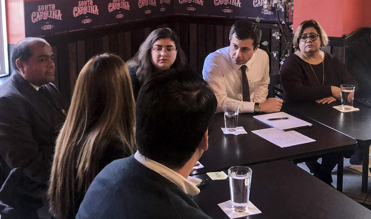 Democratic candidate Pete Buttigeig listens to Latino Milly Choy Pinto speak at Las Palmas restaurant in Okatie on Dec. 3, 2019. He attended a roundtable and discussed racism, DACA and Hurricane Maria relief with Beaufort County Democratic Party chair Mayra Rivera-Vásquez (right) and Juan Benitez (left).