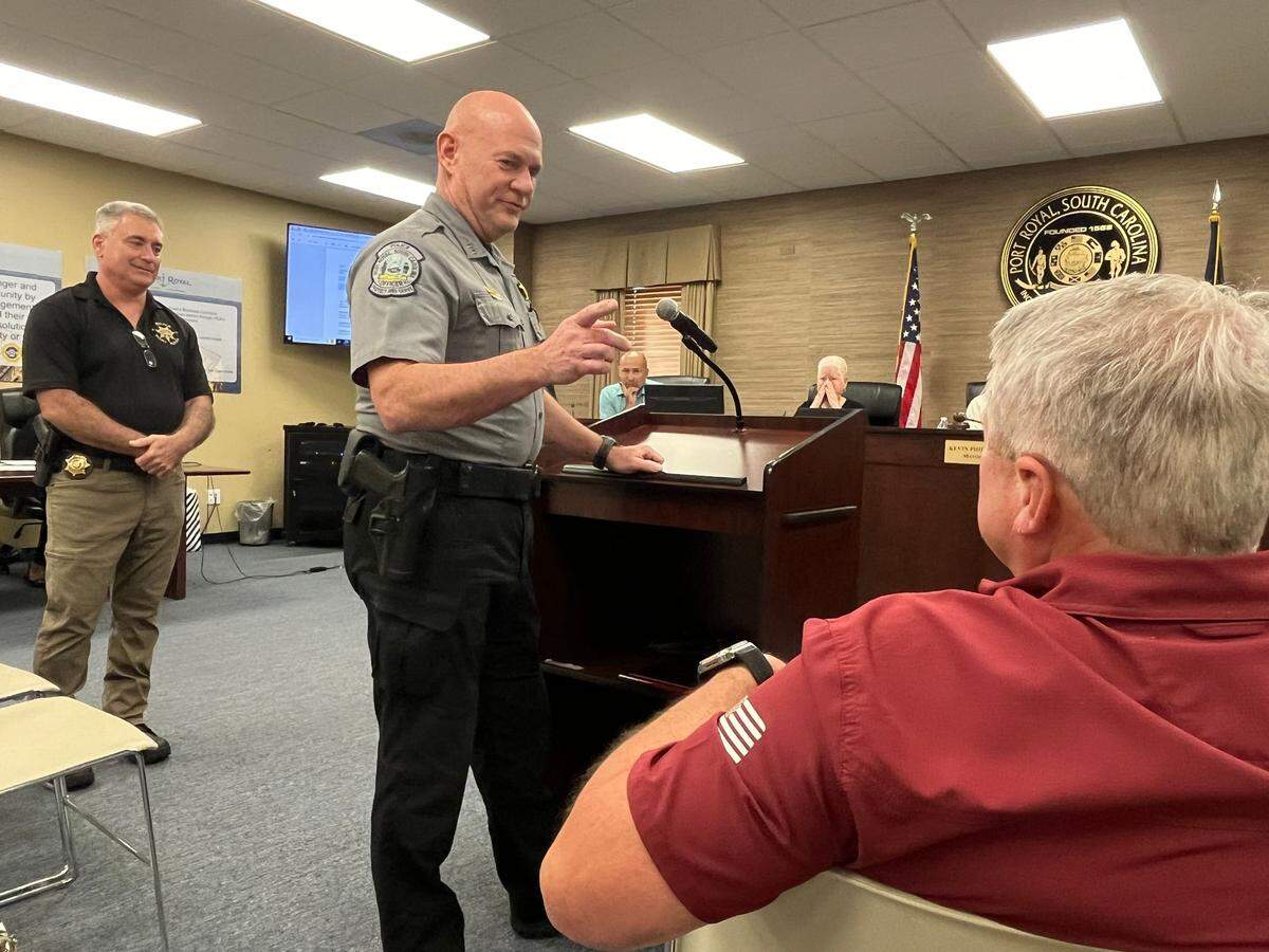 Capt. John Griffith recounts a story about Chief Alan Beach, seated, during a ceremony Wednesday when the town said goodbye to the retiring chief of police, as Deputy Chief Ron Wekenmann looks on.