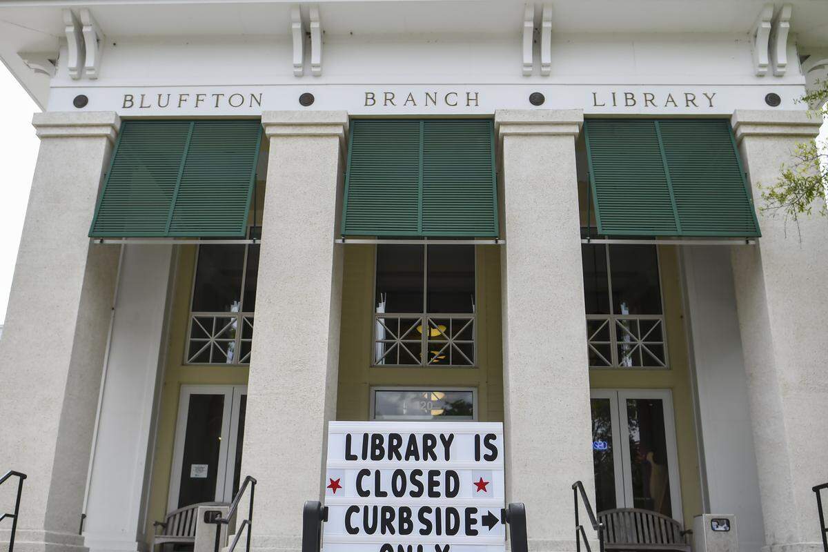 A sign at the Bluffton Branch of the Beaufort County Public Library on Tuesday, May 19, 2020, informs customers that the library is closed and directs those for pick-up service for books and DVDs to the side parking lot. Here’s how it works: After members call their local branch to request an item. Between the weekday hours of 12 p.m. to 4 p.m., customers park in a designated area, call upon their arrival and a librarian will place the item in the trunk of the car.