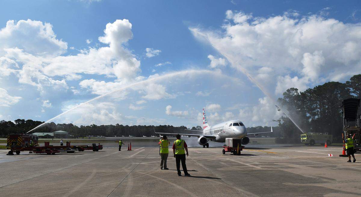 The first Embraer ERJ-175 regional jet to arrive at Hilton Head Airport is saluted with arched water streams from fire trucks as it arrives at the terminal on July 5, 2018. The plane was the first regularly scheduled commercial jet aircraft to land at the airport.